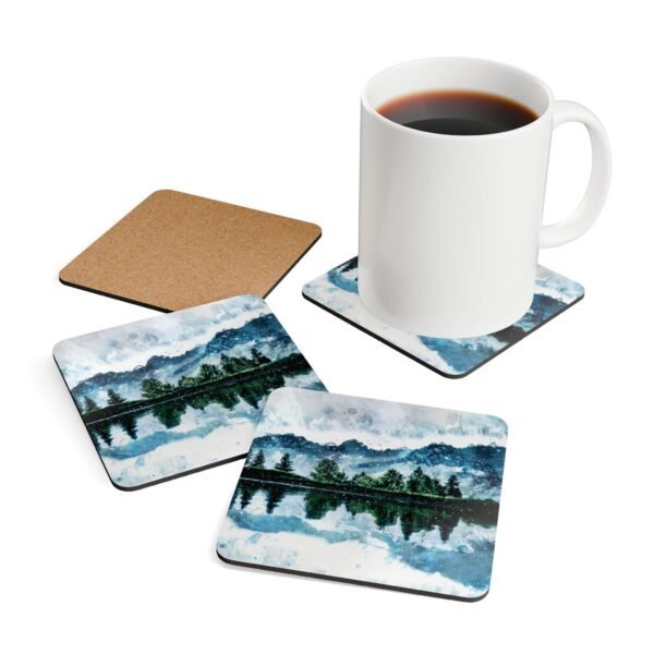 Coaster set with watercolor art print of a mountain, trees and a lake. Shown with a mug for scale.