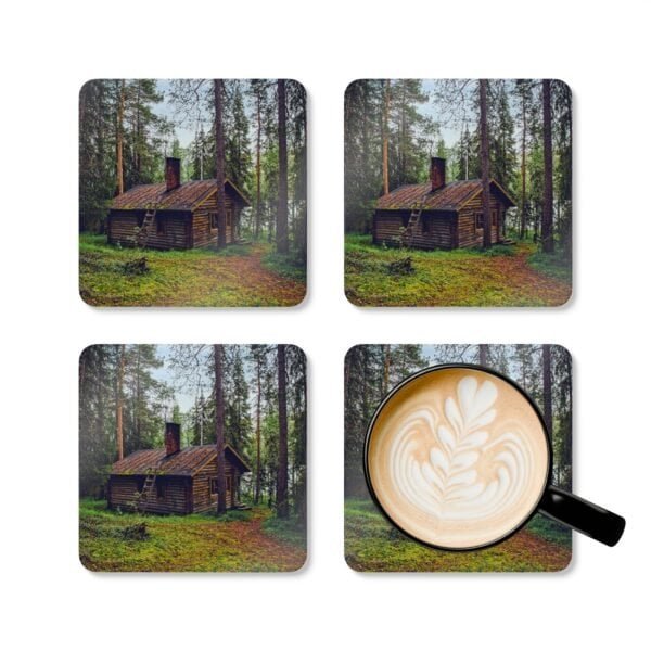 Set of 4 coasters with an image of a log cabin in a forest printed on them. Shown with a mug for scale.
