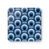 Square coaster with a blue and white mid century modern circle print design.