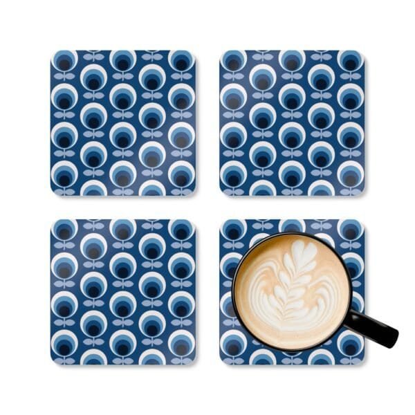 Set of 4 square coasters with a blue and white mid century modern circle print design. Shown with a mug for scale.