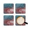 Set of 4 coasters with abstract art print in shades of turquoise blue and red. Shown with a mug for scale.
