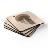 Set of four square coasters with minimalist neutral design in shades of brown, tan and black. Shown stacked on a table.