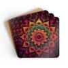 Set of 4 square coasters with image of a bright hot pink, orange and yellow mandala printed on them. Shown stacked on a table.
