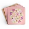 Set of 4 pink watercolor style floral coasters stacked on a table.