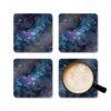 Set of 4 square coaster with black galaxy marble design in purples turquoise tones. Shown with a mug for scale.