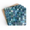 Colorful square mosaic design in shades of turquoise and teals coaster flat on table.