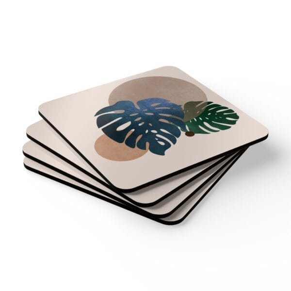 Set of four square coasters with a neutral boho design with Monstera leaves. Shown stacked on a table.