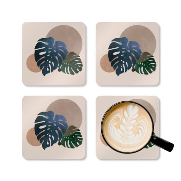 Set of four square coasters with a neutral boho design with Monstera leaves. Shown with a mug for scale.