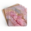 Set of 4 square coasters with pink and gold glitter design print that looks like marble. Shown stacked on a table.