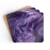 Set of 4 square coasters with purple marble print. Shown stacked on a table.