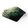 Set of four square coasters with image of misty green and grey forest landscape with layered trees fading into soft mountain fog.