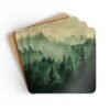 Set of four square coasters with image of misty green and grey forest landscape with layered trees fading into soft mountain fog.